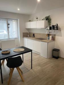 a kitchen with a table and a table and a dining room at Studio spacieux proche gare et centre ville in Saint-Amand-les-Eaux