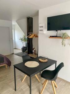 einen schwarzen Tisch und Stühle im Wohnzimmer in der Unterkunft Studio spacieux proche gare et centre ville in Saint-Amand-les-Eaux