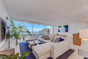 a living room with white furniture and large windows at Luxury triplex + pool, jacuzzi - SissiPark Azul in Acantilado de los Gigantes