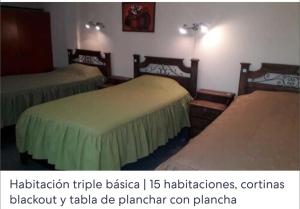 Habitación de hotel con 2 camas con colchas verdes en Hotel Oasisa, en Uyuni