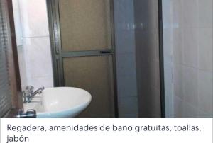 y baño con ducha, lavabo y aseo. en Hotel Oasisa, en Uyuni