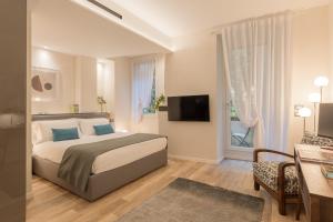 a bedroom with a bed and a desk and a television at Orti Manara Design Apartments in Verona