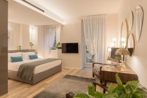 a bedroom with a bed and a desk and a television at Orti Manara Design Apartments in Verona