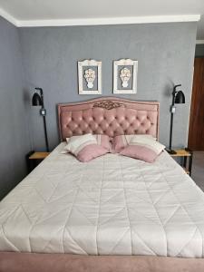 ein Schlafzimmer mit einem großen weißen Bett mit rosa Kissen in der Unterkunft CASA DINAMARCA in Santa Teresa