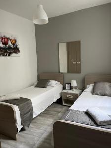 1 Schlafzimmer mit 2 Betten und einem Spiegel in der Unterkunft F8-2 Room 2 single beds shared bathroom in shared Flat in Msida