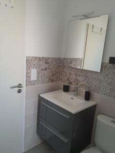 Un baño con lavabo, inodoro y espejo. en Maison vendéene bord de mer - env 1 km plage-, en Saint-Vincent-sur-Jard