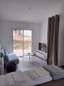Sala de estar blanca con cama y sofá en Maison vendéene bord de mer - env 1 km plage-, en Saint-Vincent-sur-Jard