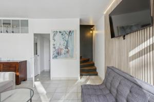 a living room with a couch and a tv at Hôtel Robespierre Ex Idéal hôtel Paris - Montreuil in Montreuil
