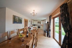 a dining room and kitchen with a table and chairs at Beech Tree Eco Lodge in Brecon