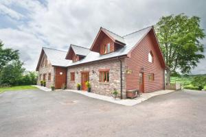 a large red barn with a large driveway at Beech Tree Eco Lodge in Brecon