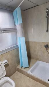 y baño con bañera, aseo y cortina de ducha. en Abu Dhabi Tourist Club-Hotel Home Stay, en Abu Dabi