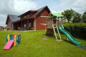 a playground with a slide in a yard at Beech Tree Eco Lodge in Brecon