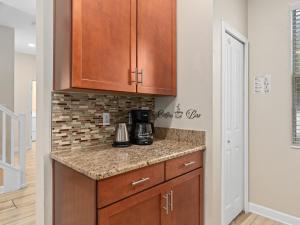 a kitchen with wooden cabinets and a counter top at Villa at Champions Gate Resort in Orlando near Theme Parks with Private Pool, SPA & Movie Theater in Davenport