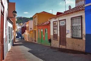 un callejón con edificios coloridos en una calle de la ciudad en Apartamento Rebeca en Tazacorte