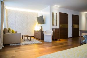 1 dormitorio con sofá y silla en una habitación en Iris Porsche Hotel & Restaurant, en Mondsee