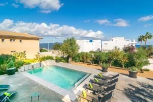 a swimming pool with chaise lounge chairs next to a building at Casa del Mar in Son Serra de Marina