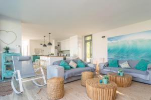 a living room with two couches and a kitchen at Casa del Mar in Son Serra de Marina
