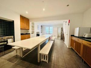 uma cozinha com uma mesa e bancos em Modern & Glamorous Home Brighton Pier Beach SLP16 em Brighton & Hove