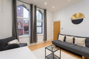 ein Wohnzimmer mit einem Sofa und einem Tisch in der Unterkunft Oxford Row Apartments, Leeds City Centre in Leeds
