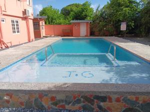 una piscina en medio de una casa en JGs Tropical Apartments, en Crown Point