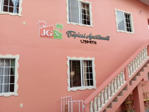 una fachada rosa de un edificio en JGs Tropical Apartments, en Crown Point