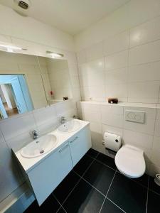 een badkamer met een wastafel, een toilet en een spiegel bij Urbanstay Suites Grand Place Luxury Apartment in Brussel