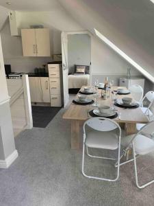 a dining room with a table and chairs and a kitchen at Stunning remote norfolk apartment in Mileham