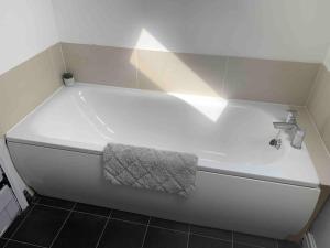 a bath tub with a towel on the side of it at Stunning remote norfolk apartment in Mileham