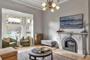 ein Wohnzimmer mit einem Kamin und einem Kronleuchter in der Unterkunft Spacious Second Empire Suite at The Platt Mansion in Buffalo