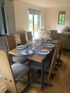 - une table à manger avec des chaises et des assiettes dans l'établissement Escape to the Cabin, à Belturbet