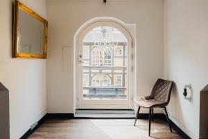 einem Torbogen mit einem Stuhl und einem Fenster in der Unterkunft Capsule Hotel Nyhavn63 in Kopenhagen