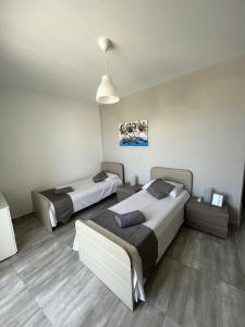 F9-3 Room 2 single beds with shared bathroom in shared Flat في مسيدا: غرفة نوم بسريرين واضاءة قلادة