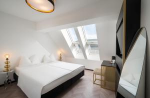 a bedroom with a white bed and a large window at elaya hotel vienna city center in Vienna