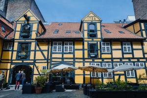 a yellow and black building with umbrellas in front of it at Capsule Hotel Nyhavn63 in Copenhagen