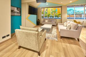 uma sala de estar com duas cadeiras e um sofá em City Express Suites by Marriott Cabo San Lucas em Cabo San Lucas