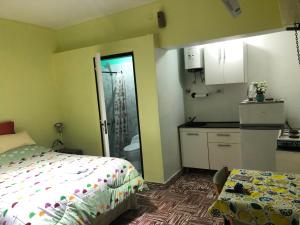 1 dormitorio pequeño con 1 cama y cocina en Monoambiente en km3 en Comodoro Rivadavia