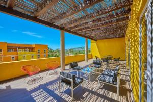 Un patio con sillas y una mesa en el balcón. en City Express Suites by Marriott Cabo San Lucas en Cabo San Lucas