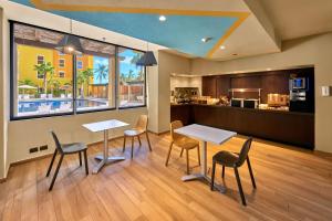 カボ・サン・ルーカスにあるCity Express Suites by Marriott Cabo San Lucasのテーブルと椅子2脚、キッチンが備わる客室です。