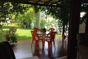 a table and four chairs on a porch with a garden at Casa de praia por temporada. in Camacari
