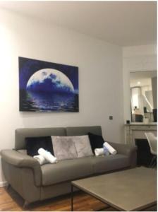 a living room with a couch and a painting on the wall at Amazing apartment- Eiffel TowerConvention in Paris