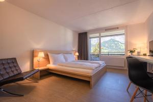 ein Hotelzimmer mit einem Bett und einem Fenster in der Unterkunft Hotel des Alpes in Flims