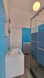 La salle de bains est pourvue d'un lavabo et d'une douche en verre. dans l'établissement Аpartements in the historical center df Vichy,hotel Imperial., à Vichy