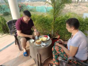 een man en een vrouw aan een tafel met een bord eten bij The Mountain View Home Stay in Khajurāho