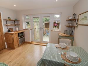 a living room with a table and a kitchen at Little Padley in Broadway