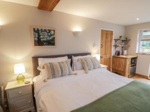 a bedroom with a bed with white sheets and pillows at Little Padley in Broadway