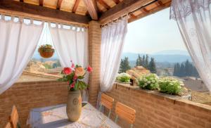 a vase with flowers on a table on a balcony at Spello House Altana in Spello