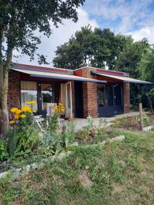 a brick house with a garden in front of it at BIESBOSCHBEST in Werkendam