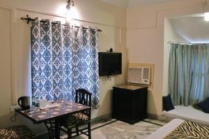 ein Wohnzimmer mit einem Tisch und einem TV in der Unterkunft Sariska Tiger Heaven in Akbarpur