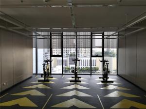 a gym with several exercise machines in a room with windows at 免费接机/空中楼阁/水果西施夜市/热带雨林/RCA/无边泳池/近地铁Rama9 in Bangkok