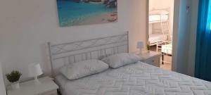una camera con un letto bianco con due cuscini di Villa Rifla Attico a Lizzano